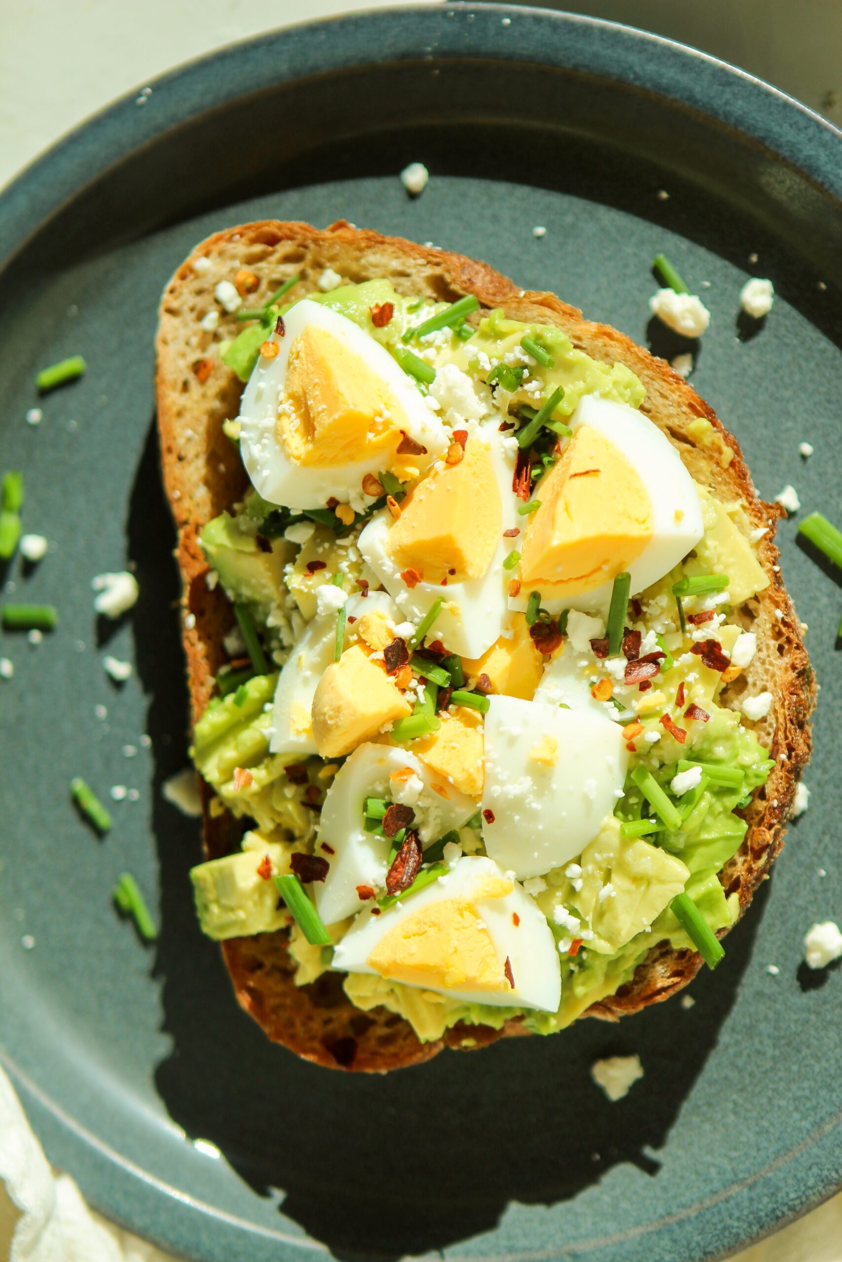 avocado toast with egg feta cheese and chives