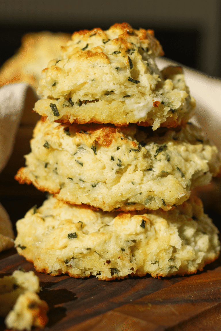 These cheddar chive cathead biscuits are packed with sharp cheddar cheese and fresh chives, with soft, flaky layers in every bite. This easy homemade biscuit recipe skips rolling and cutting—just scoop, bake, and serve!
